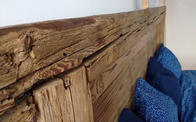 Rückwand eines Bettes aus Altholz Balken