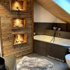 Badezimmer mit Altholzbrettern und Endbalken verbaut