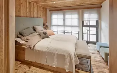 Handgehackte Altholzbretter als Wandverkleidung im Schlafzimmer