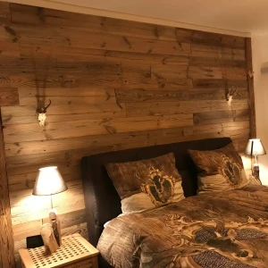Schlafzimmerwand verkleidet mit Altholzbretter und gehackten Balken